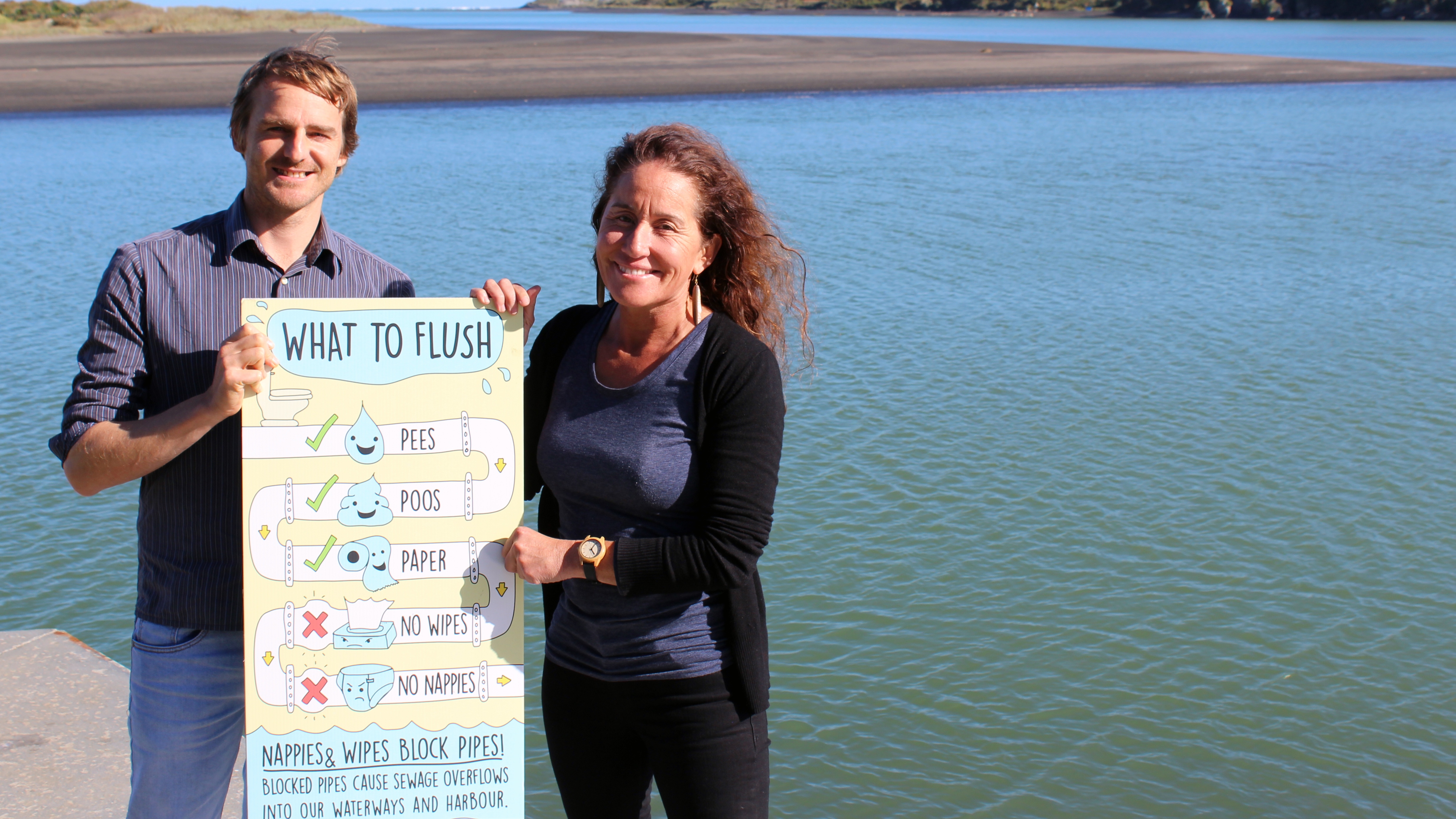 Raglan graphic designer Leighton Davies and Raglan Ward Councillor Lisa Thomson show an example of a poster produced for Waikato District Council’s wastewater system public education campaign.